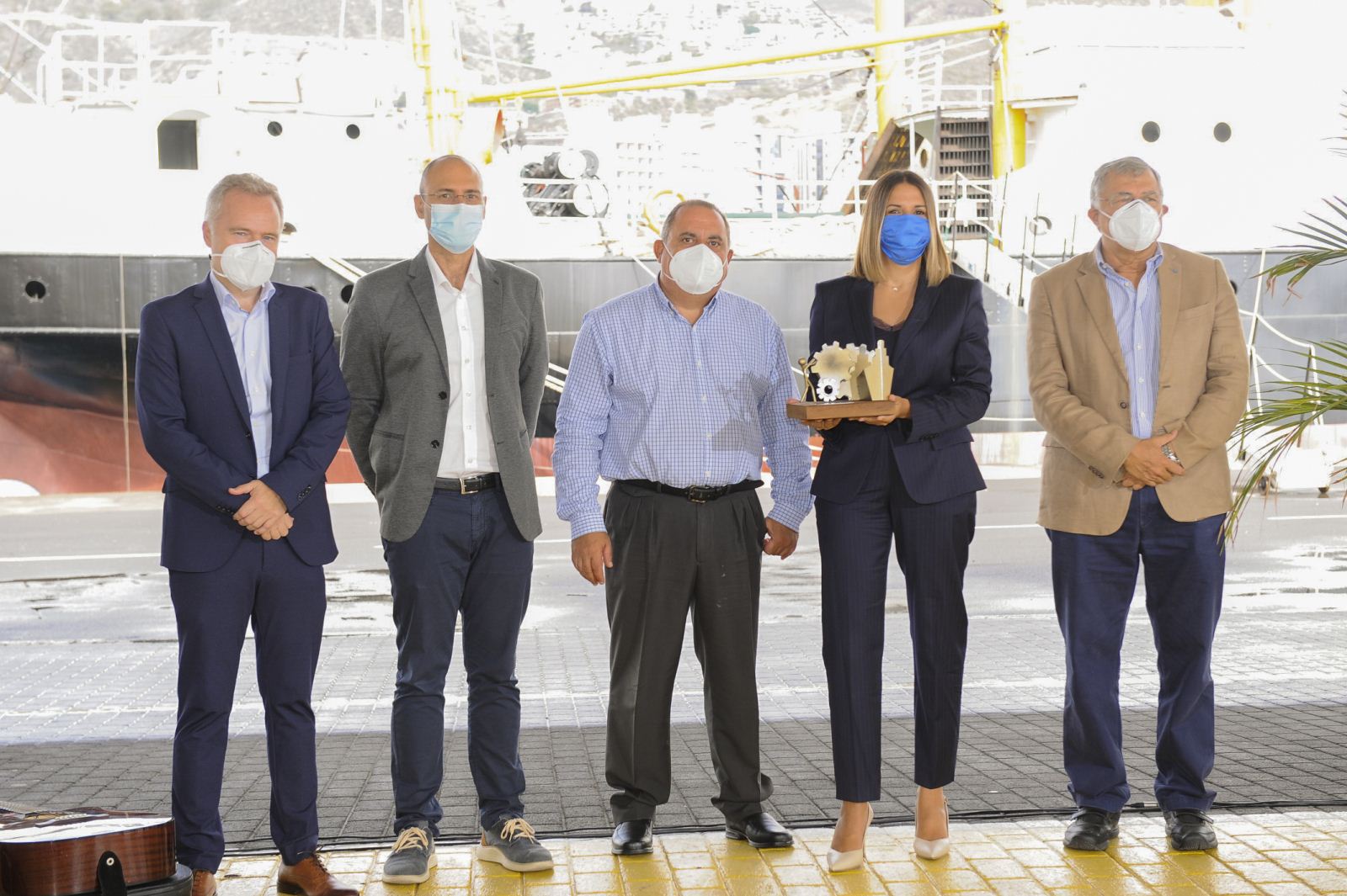 La directora de RRHH de Fred. Olsen, S.A., Zahily Pérez, junto a parte del equipo de PRL, Manuel León y Mauro Rodríguez, recogen el Premio entregado por el director de la Autoridad Portuaria, Aitor Acha, y el presidente de la misma, Carlos González.